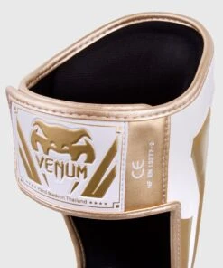 Venum ELITE Shin Guards - White/gold -Fighters Europe Shop e60a097ecd90455a1197448726fe930595673983 IMG 0320 2 copie
